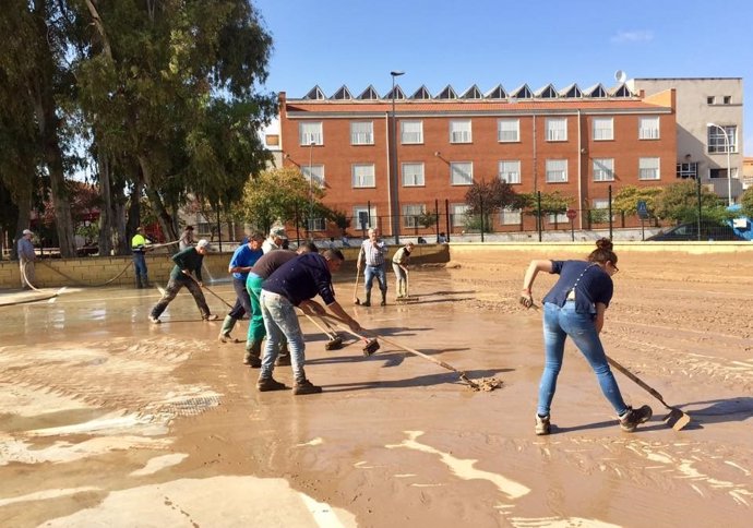 Vecinos trabajan en campillos quitar barro lodo lluvias temporal colegio ayuda 