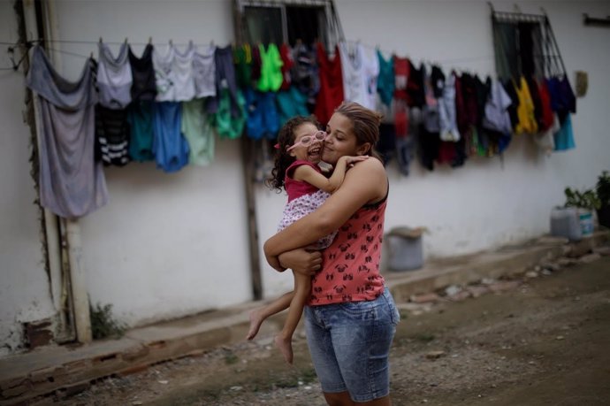 Una mujer con su hija, que padece micocefalia debido al virus zika, en Brasil.