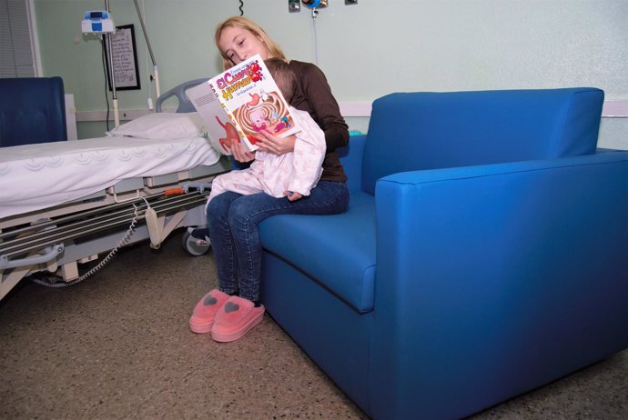 Una mujer en un sillón cama en Oncohematología pediátrica.