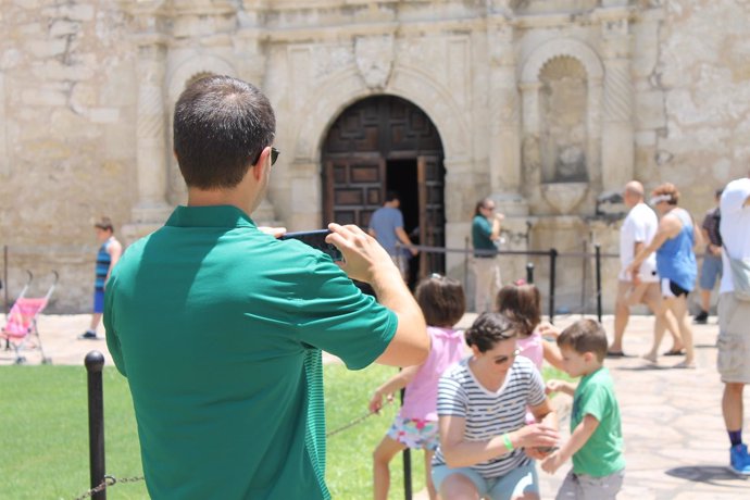 Padre haciendo foto con móvil a madre e hijo