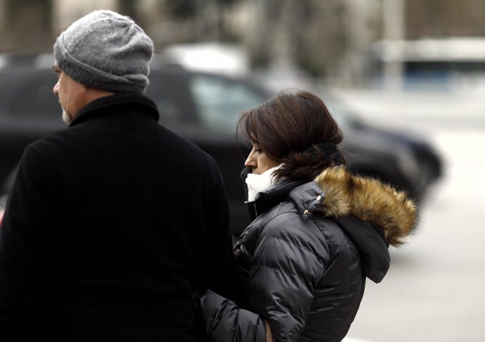 Dos personas caminan por la calle un día de invierno 