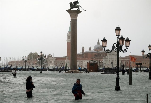 Varias personas en la Plaza San Marcos durante la 'acqua alta' en Venecia