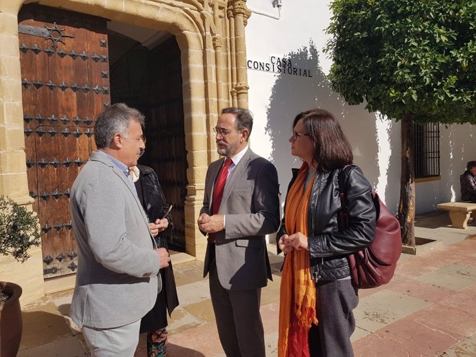 El consejero (centro) habla con el alcalde de Villa del Río ante el Ayuntamiento