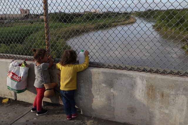 Honduran girls look out at the Rio Grande on the Mexican side of the Brownsville