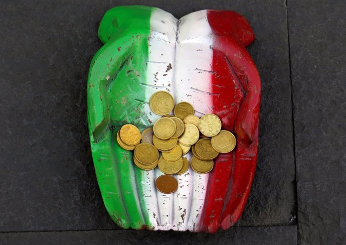 Monedas de euro en unas manos con la bandera de Italia