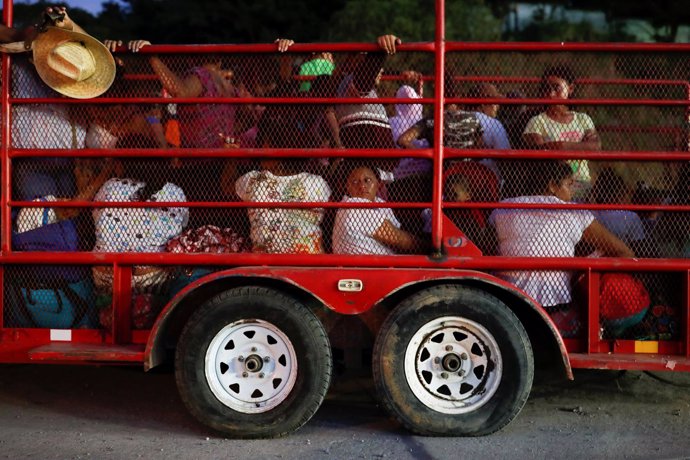 Migrants, part of a caravan traveling en route to the United States, ride in a t