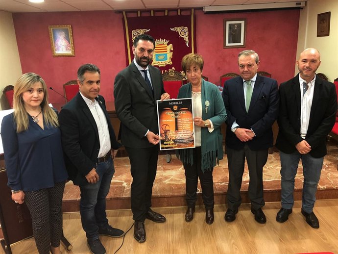 El consejero y la alcaldesa (centro) con el cartel de la Fiesta del Vino Nuevo