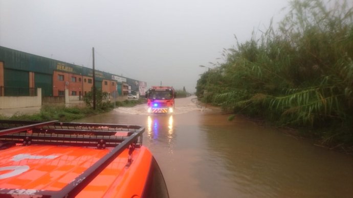Bombers actuant en la zona de la Ribera inundada per les pluges