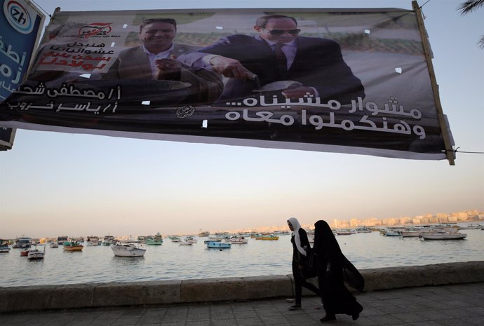Mujeres bajo un cartel de Abdelfatá al Sisi