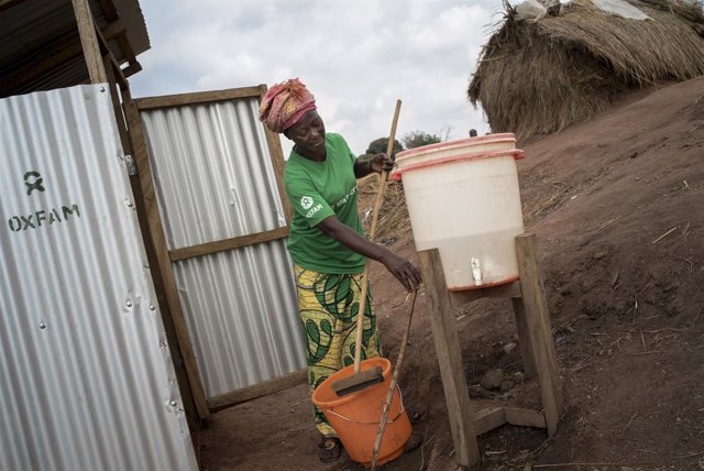 Trabajadora de Oxfam limpia una letrina en un campo de desplazados en RDC