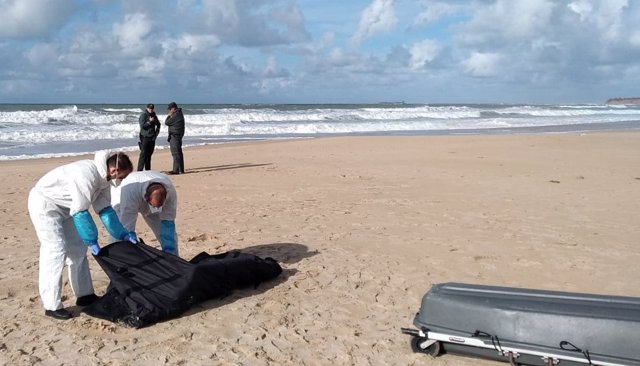 Servicios funerarios recogen el cadáver de un inmigrante en la playa en Chiclana