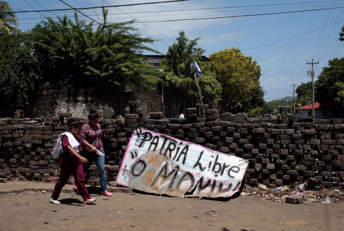 Mujeres junto a una pancarta tras las manifestaciones en Nicaragua