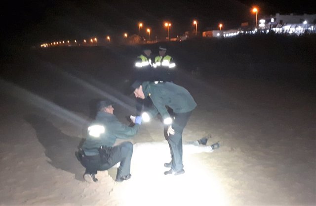 Guardias civiles con el cadáver de un inmigrante aparecido en el Palmar, Vejer