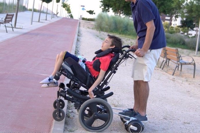 José, paseando a su hijo José, con una silla de ruedas mejorada
