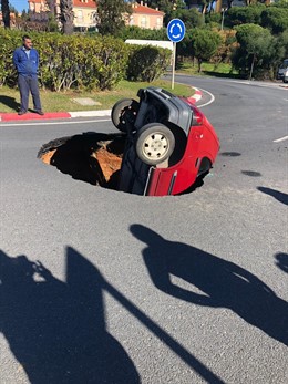 Un coche cae en un socavón al ceder el pavimento cuando pasaba.