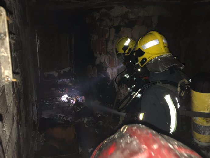Bomberos de Málaga sofocando un incendio en una vivienda