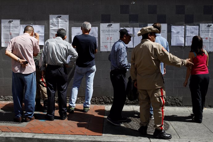 People check electoral lists at a polling station during the municipal legislato