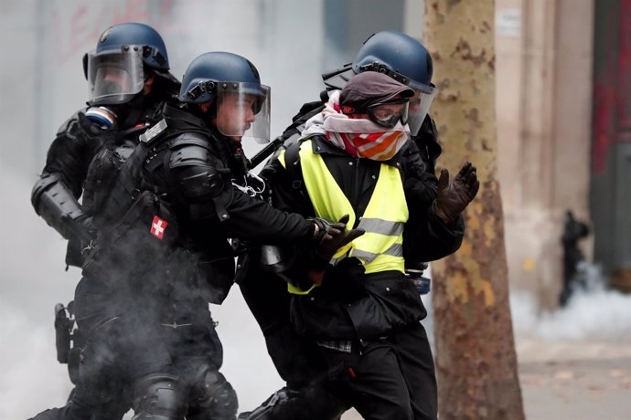Gendarmes gales detienen a un encapuchado en una protesta de chalecos amarillos