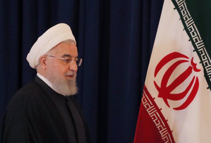 Hasán Rohani junto a la bandera de Irán