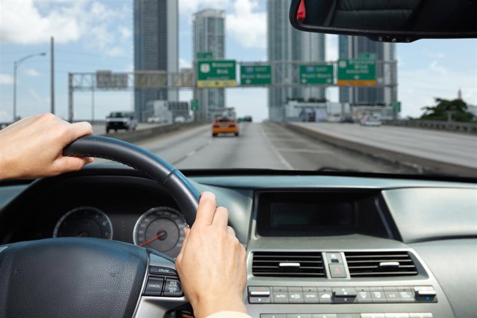 Car driver hands. People driving on driveway.