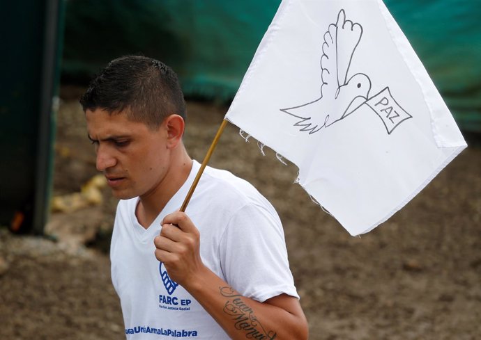 Guerrillero de las FARC sostiene una bandera con la paloma de la paz