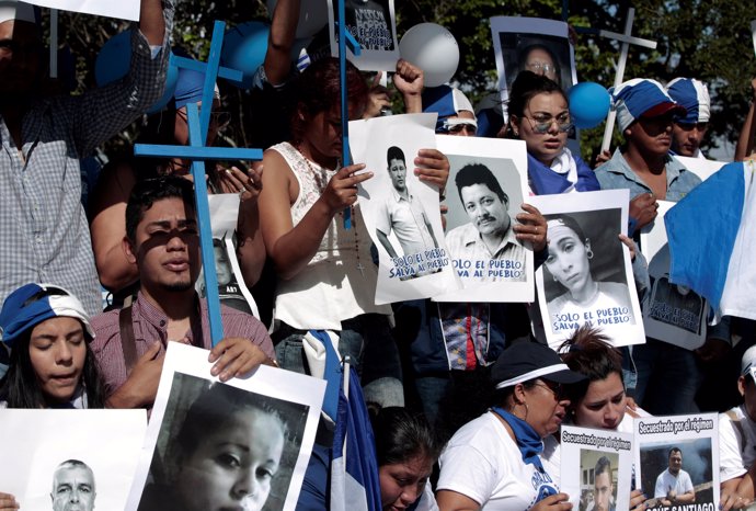Nicaraguan expats living in Costa Rica hold pictures of people killed in riots o