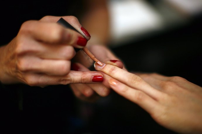 Una persona pintándose las uñas