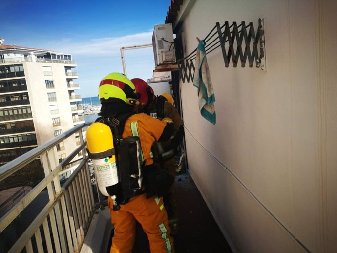 Dos efectivos de bomberos en la azotea del edificio afectado
