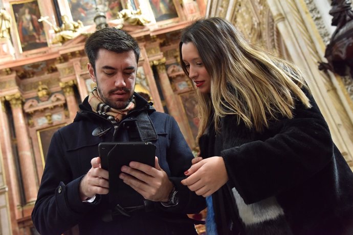 Una pareja usa la nueva guía multimedia en la visita a la Mezquita-Catedral