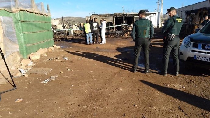 Agentes vigilan la zona de chabolas afectada por el incendio en Níjar (Almería)