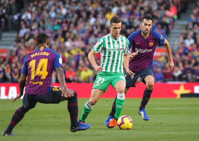 Lo Celso conduce la pelota ante Busquets y Malcom