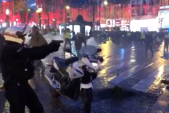 Un policía saca su pistola durante los disturbios en París