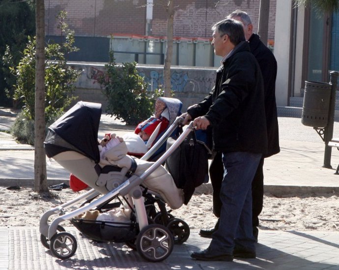 Unos padres pasean a sus bebés