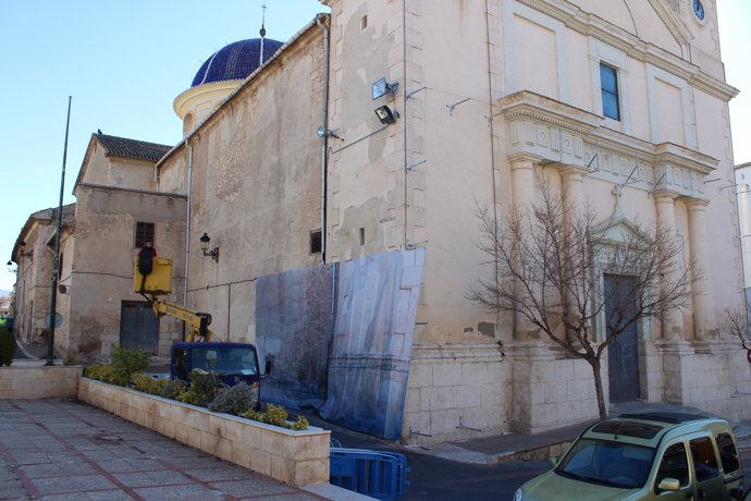 Operarios instalan la lona de protección de la Iglesia de Ibi ante Els Enfarinat