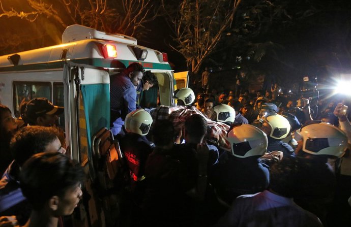 Los bomberos socorren a una víctima de un incendio en un edificio Bombay, India