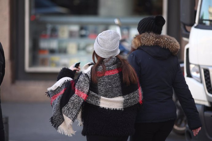 Jóvenes caminan por la calle un día de invierno 