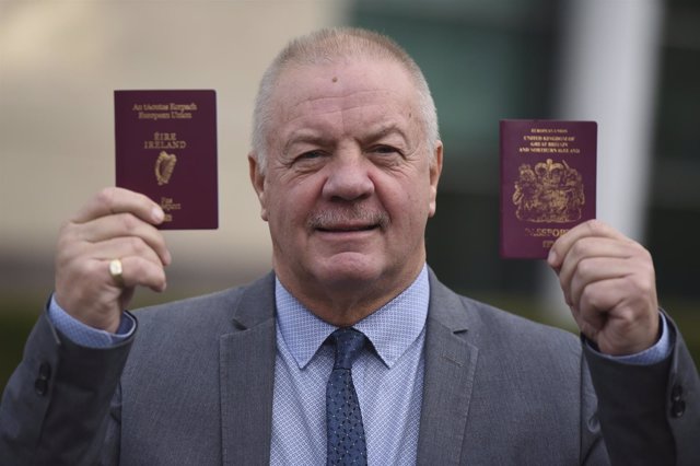 Raymond McCord mostrando un pasaporte irlandés y un de Reino Unido