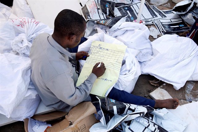 Un hombre examina material electoral en República Democrática del Congo