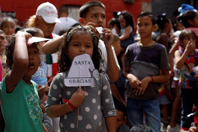 A girl holds a sign, which reads: "Thanks, Santa", during the "Santa en las call