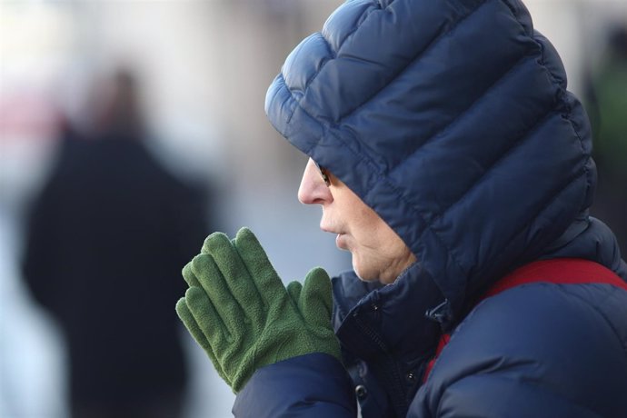 Un hombre se abriga ante el frío 