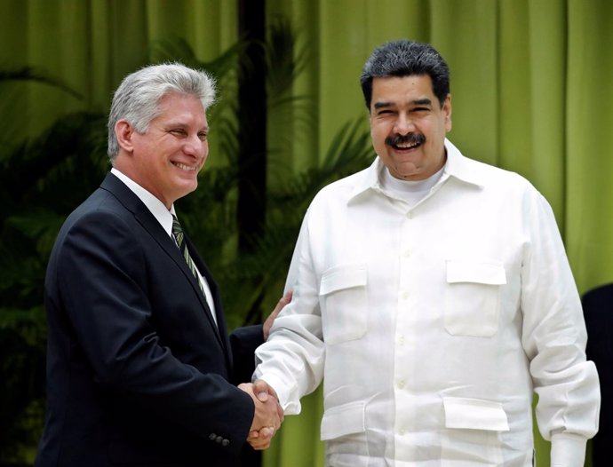 Cuba's President Miguel Diaz-Canel (L) shakes hands with Venezuela's President N