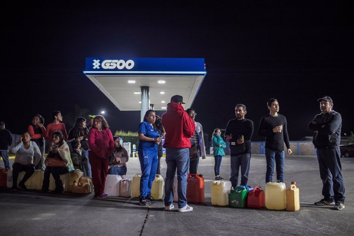 People queue to buy gasoline at a gas station after an offensive by Mexico's gov