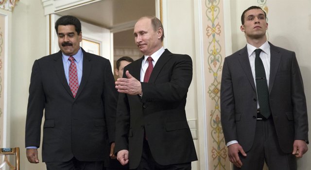 Russian President Vladimir Putin (C) shows the way to his counterpart from Venez