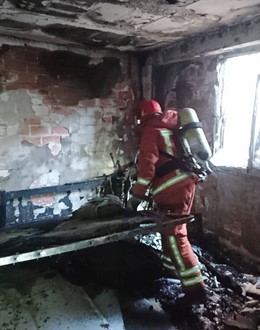 Un bomber en les tasques d'extinció de l'incendi de Sedaví