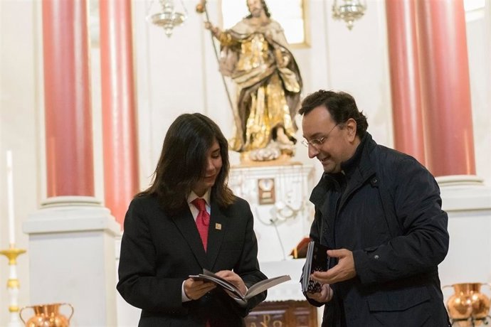 Un turista (dcha.) es atendido en su visita a una iglesia fernandina