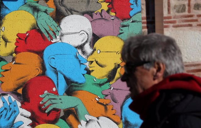 A man walks past "Run" artpiece painted by Italian street artist Giacomo Bufarin