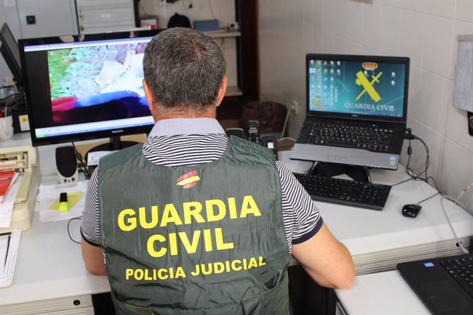 Un agente de la Guardia Civil inspecciona archivos en un ordenador