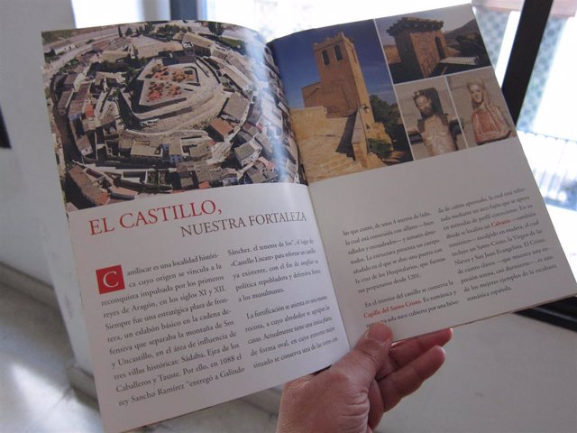 Una turista consulta un folleto sobre los monumentos de Castiliscar