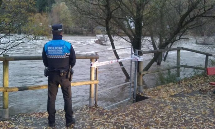 Un policía municpal vigilando la crecida del río Arga en Pamplona