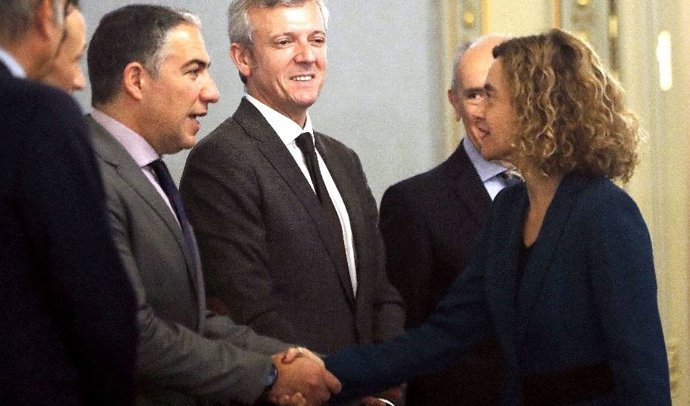 Elías Bendodo y Meritxell Batet se saludan en la reunión con las comunidades